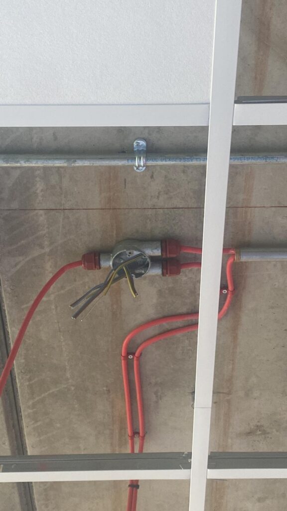 a pipe with wires attached to the ceiling